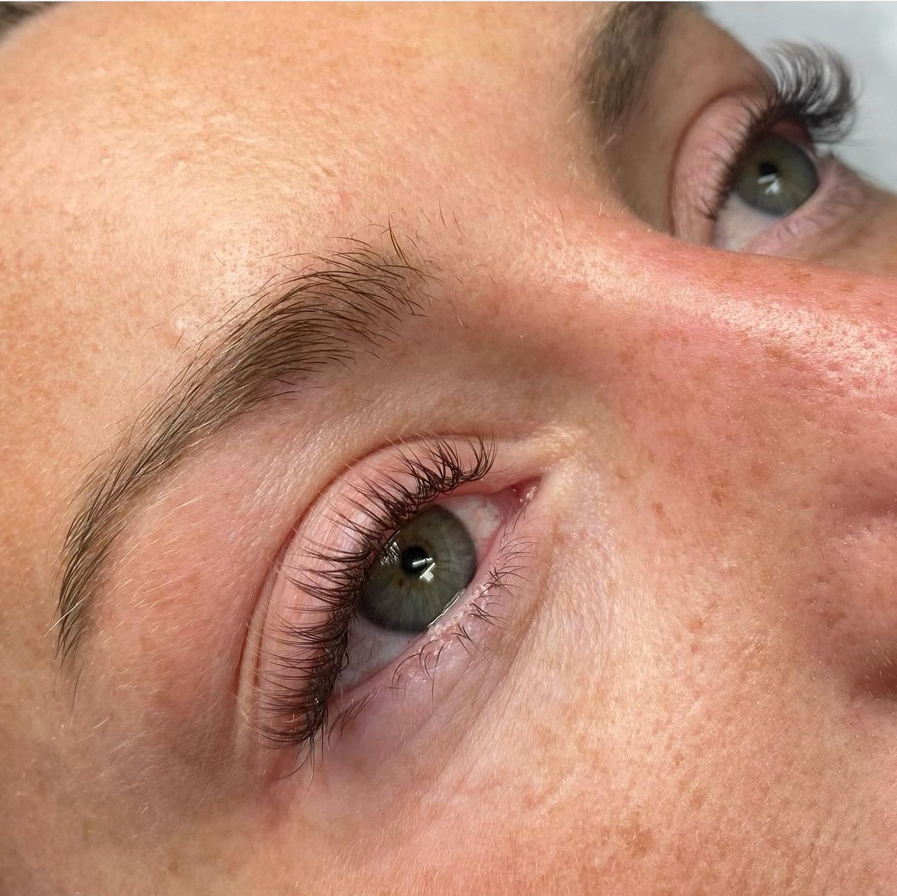 Detailed view of a woman's eyes with lush, full lashes, showcasing the dramatic results achieved with Belo Lash products.