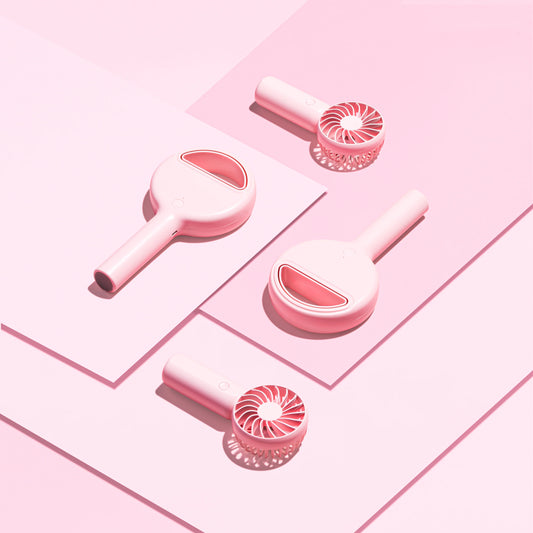 Four lash fans lying against a pink background.