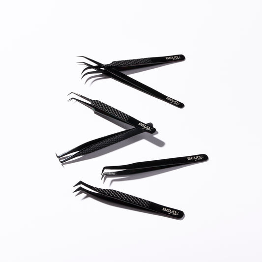 Lash tweezers are scattered on a white background