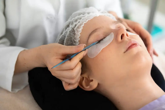 Professional examining eyelash mites with a blue tool, showcasing a procedure related to eyelash care