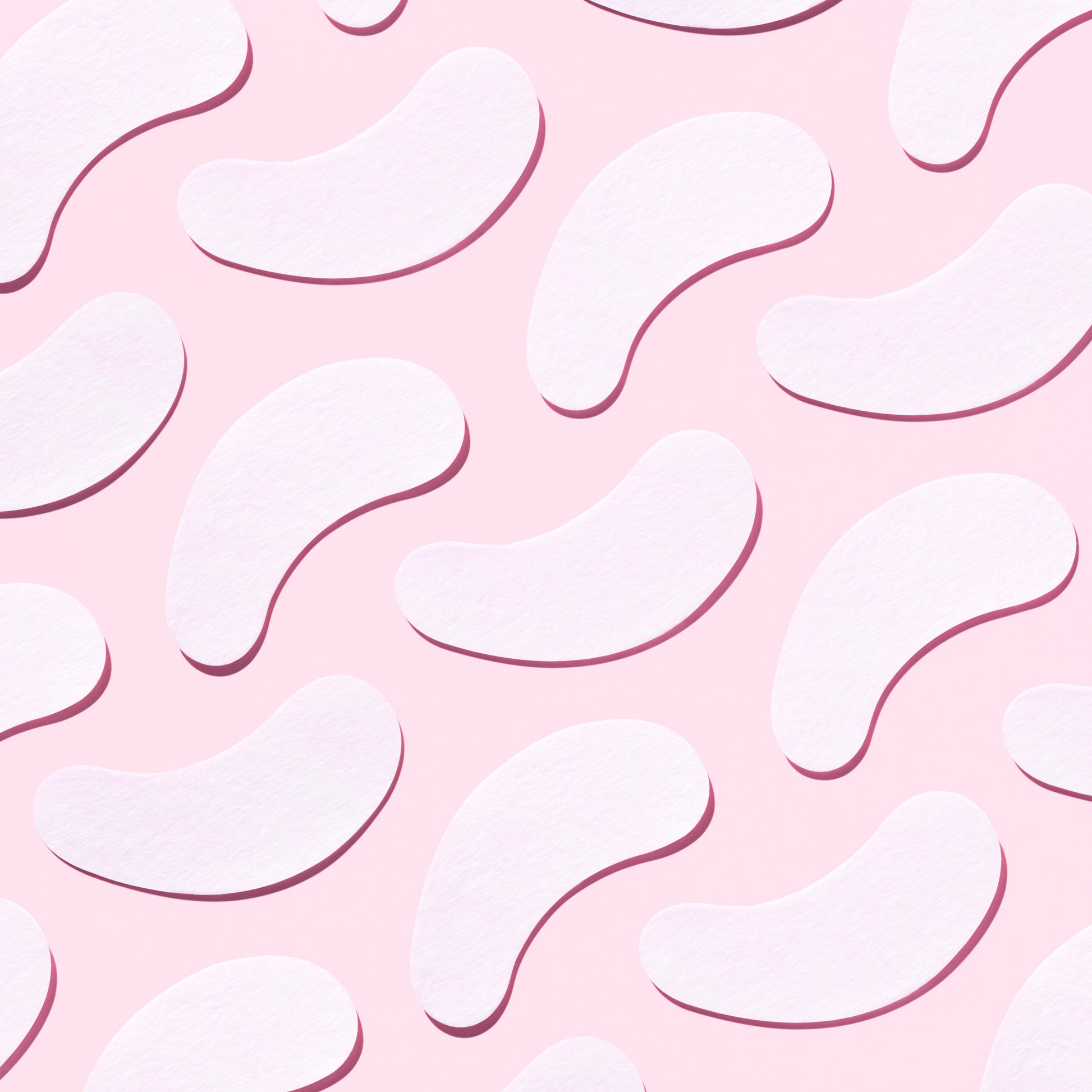 BELO Lash Hydrogel eye pads neatly arranged on a pink background, showcasing their sleek design and premium quality.